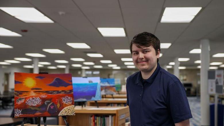 Jacob Campbell standing next to his painting